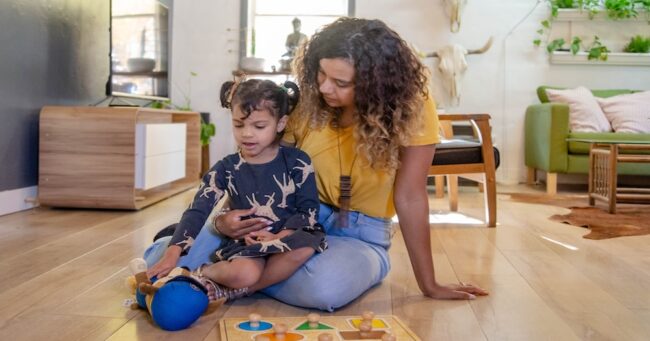 A mom and preschooler playing on the floor