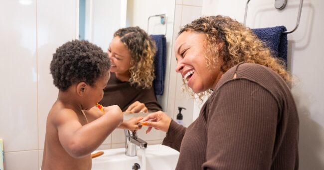 Mom and child brushing teeth after a bath