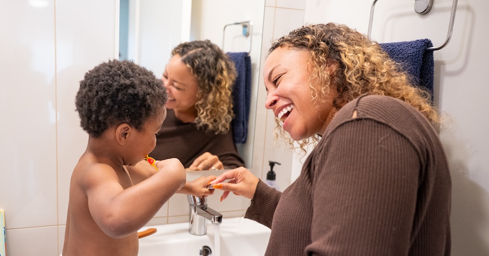 Mom and child brushing teeth after a bath